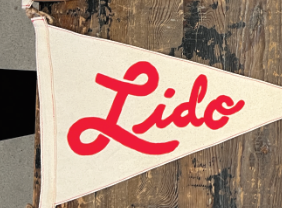 A close-up of the Lido brand burgee with red and cream colors, displaying the word 'Lido' prominently in the center.