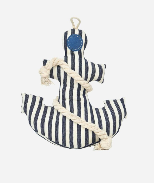 A nautical anchor-shaped fabric wall hanging or plush decoration with navy and white vertical stripes, a blue circular patch near the top, and a thick cream rope wrapped around it, shown on a plain light gray background.
