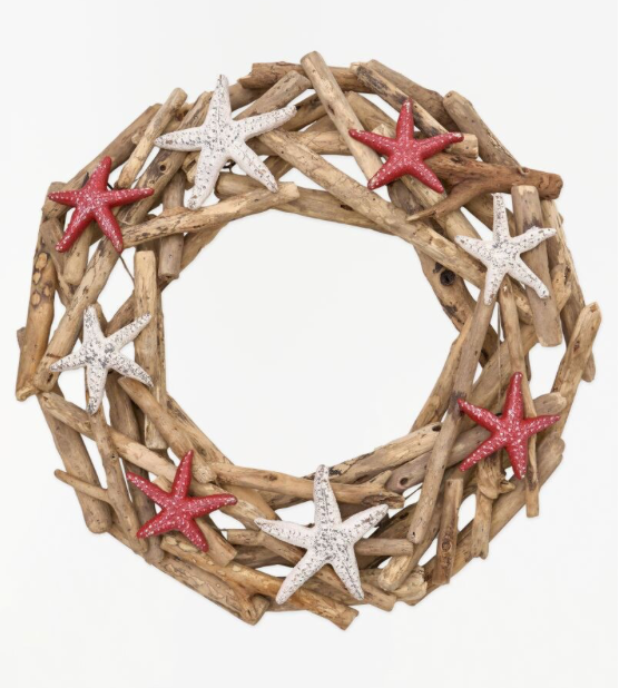 A circular nautical wreath made of natural driftwood branches, decorated with five glittery starfish in red and white, shown against a plain white background.