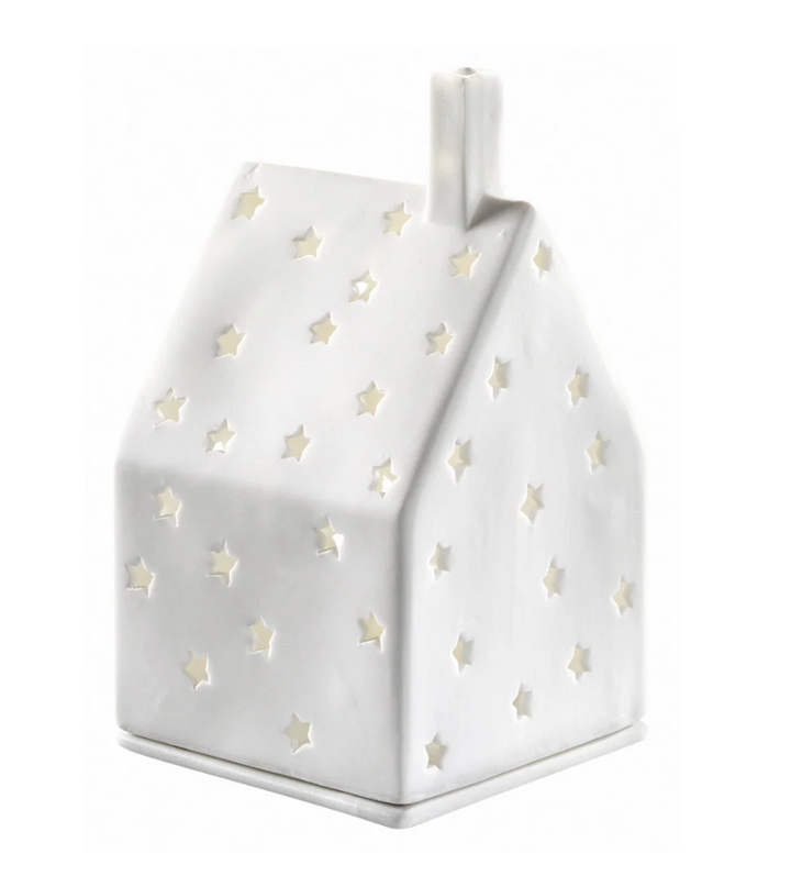A white house-shaped ceramic lamp or decorative holder with star-shaped cutouts, shown on a plain white background.
