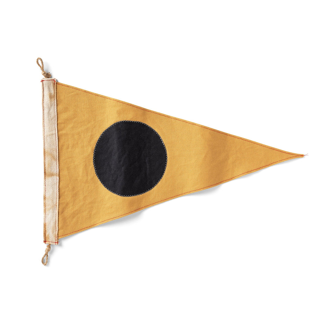 Triangular flag with a black circle on a mustard yellow background