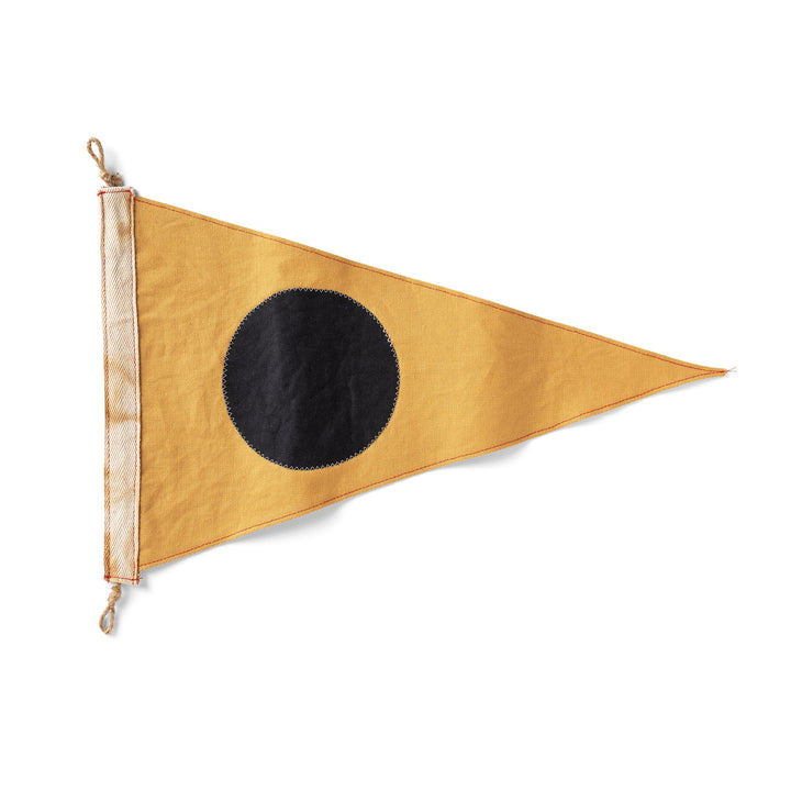 Triangular flag with a black circle on a mustard yellow background
