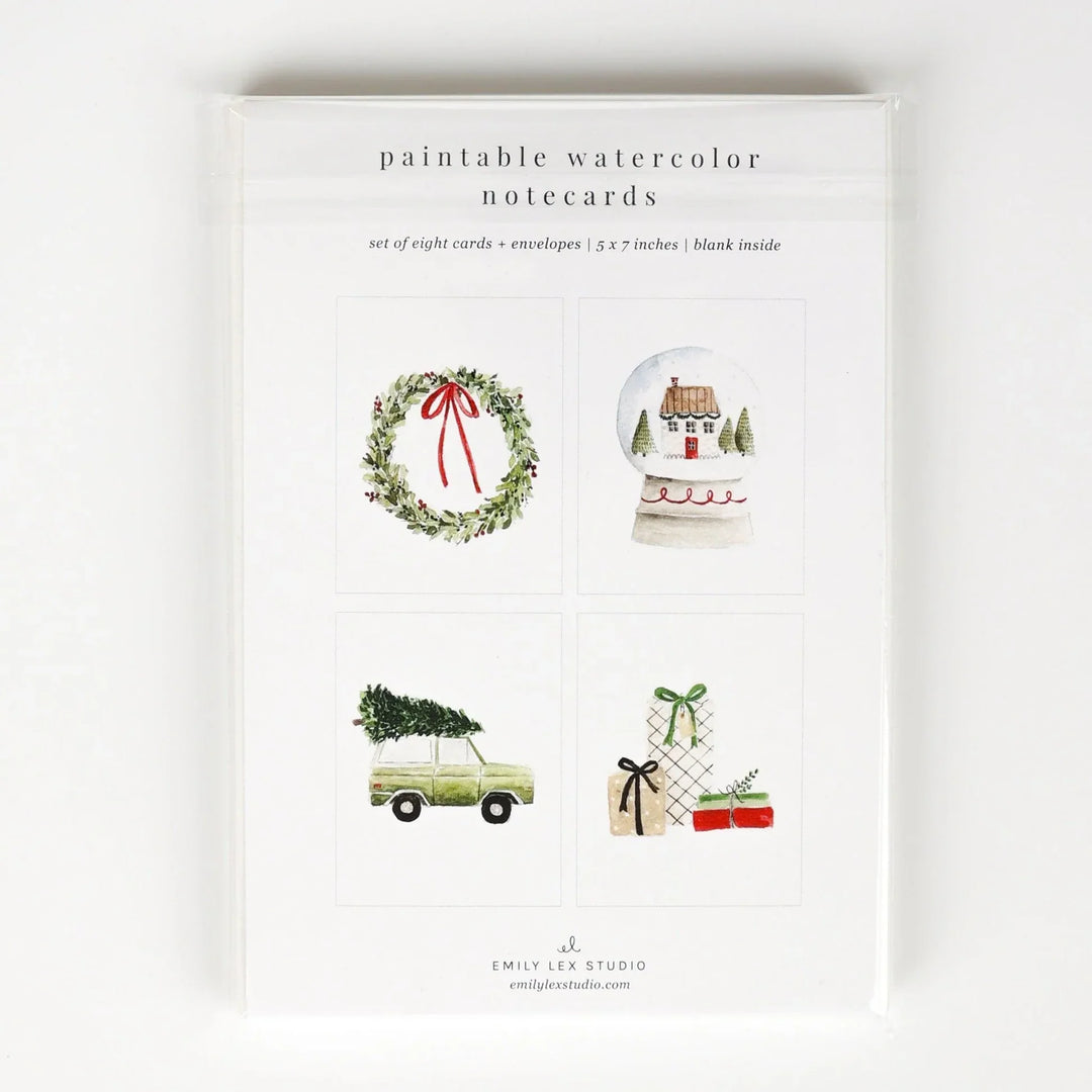 A package of 'paintable watercolor notecards' by Emily Lee Studio, featuring four watercolor holiday illustrations: a green wreath with a red bow, a snow globe with a house, a vintage car carrying a Christmas tree, and wrapped gifts with bows.