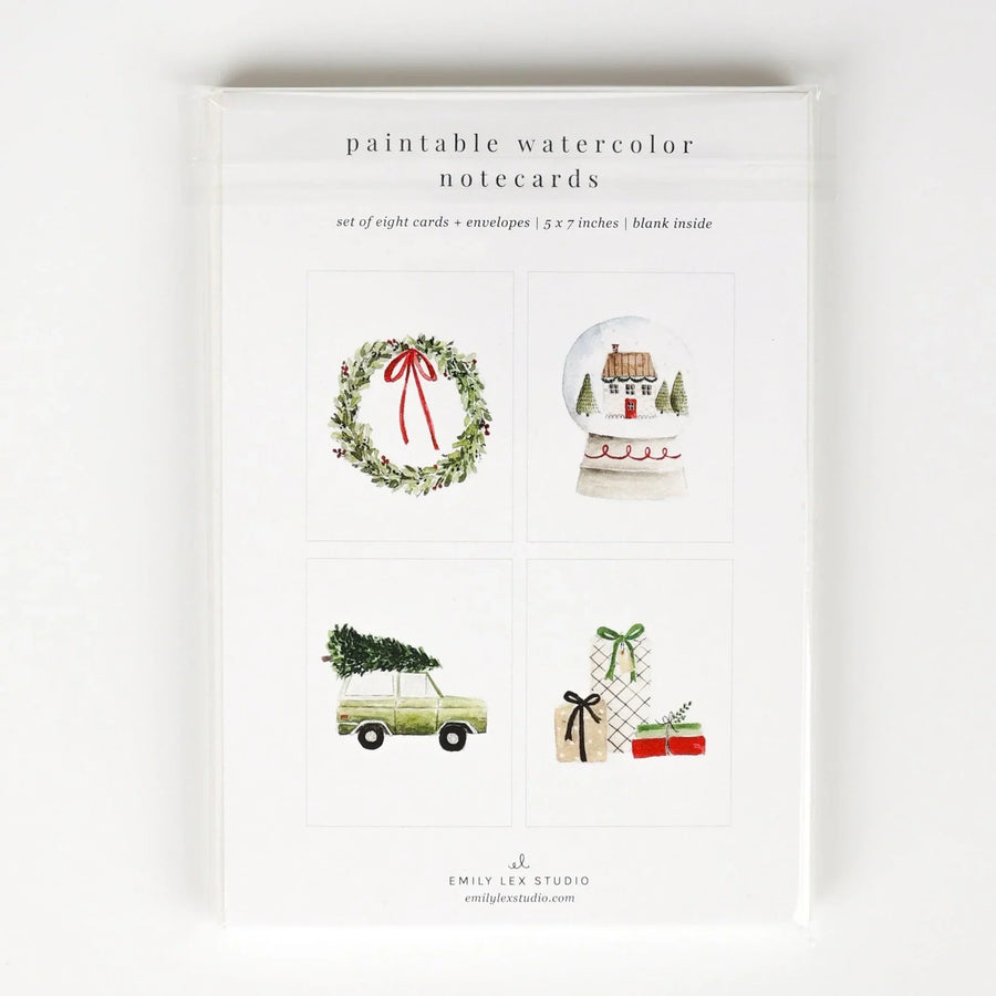 A package of 'paintable watercolor notecards' by Emily Lee Studio, featuring four watercolor holiday illustrations: a green wreath with a red bow, a snow globe with a house, a vintage car carrying a Christmas tree, and wrapped gifts with bows.