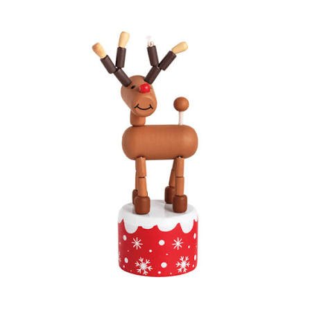 A wooden toy reindeer figurine with articulated limbs and antlers, standing on a red cylindrical base decorated with white snowflakes and a white faux-snow top, against a plain white background.